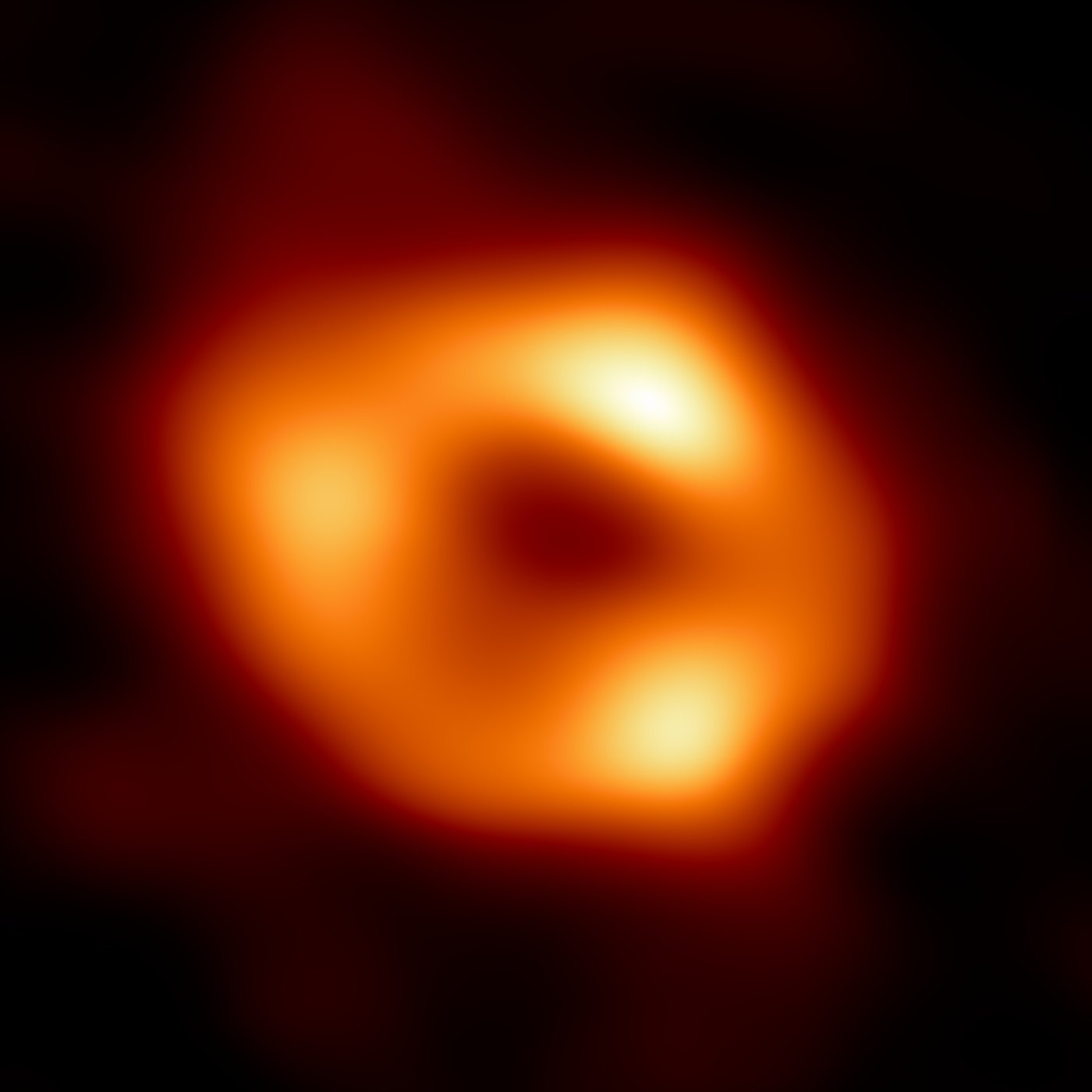 The Event Horizon Telescope's image of Sagittarius A*: an orange ring with three bright knots around a dark centre.